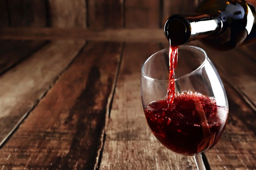 Red wine is poured from bottle to glass